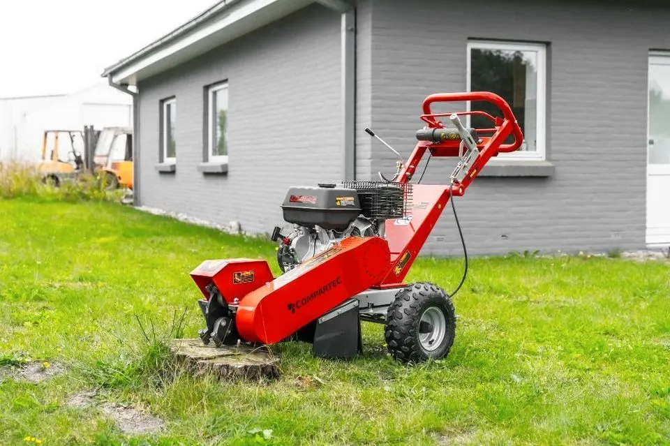 Die rote Wurzelfräse auf einem Rasen vor einem grauen Haus
